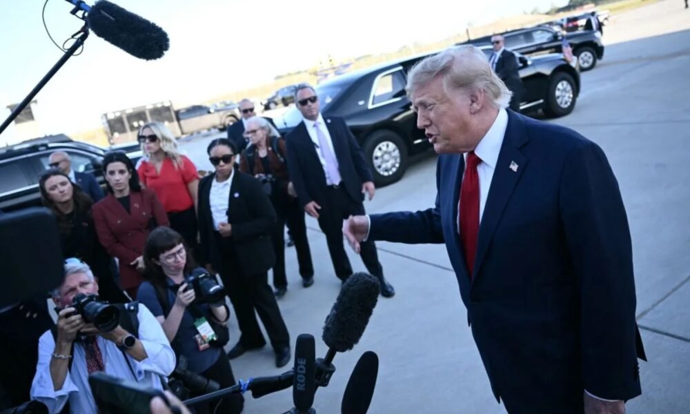 Donald Trump fala com jornalistas diante de câmeras e microfones
