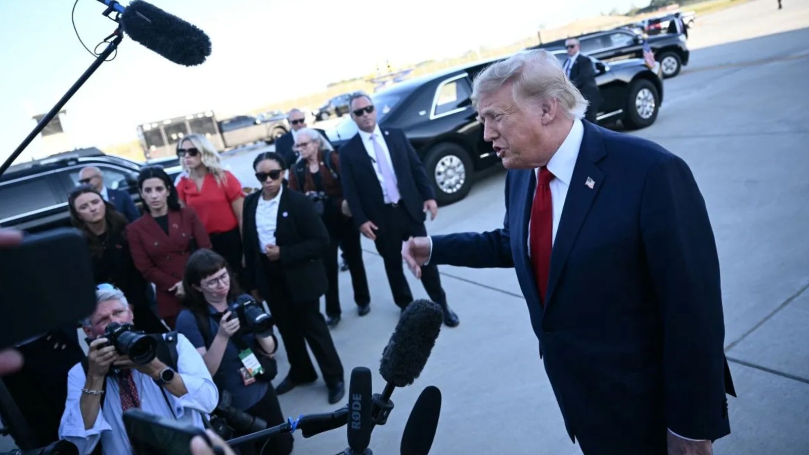 Donald Trump fala com jornalistas diante de câmeras e microfones