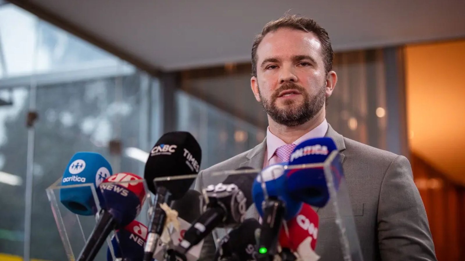 Dario Durigan fala à imprensa diante de microfones