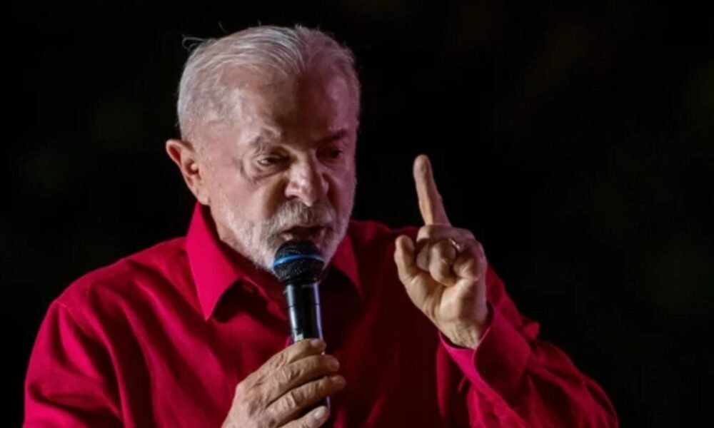 Lula fala ao microfone com o dedo erguido