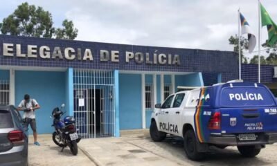 Delegacia de Polícia com viaturas estacionadas em frente ao prédio.