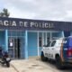 Delegacia de Polícia com viaturas estacionadas em frente ao prédio.