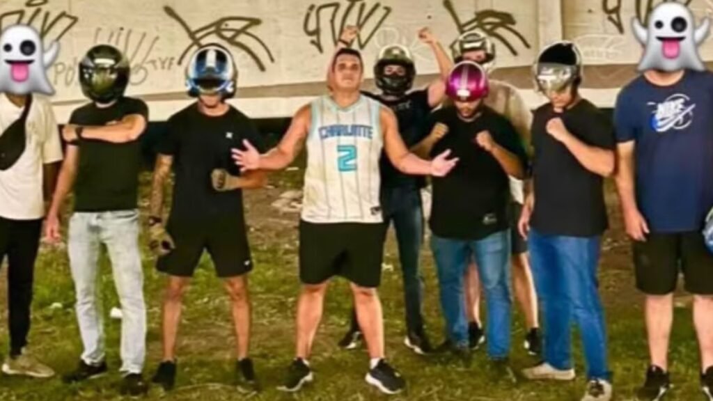 William Correia ao centro de um grupo de pessoas, algumas com capacetes e rostos cobertos