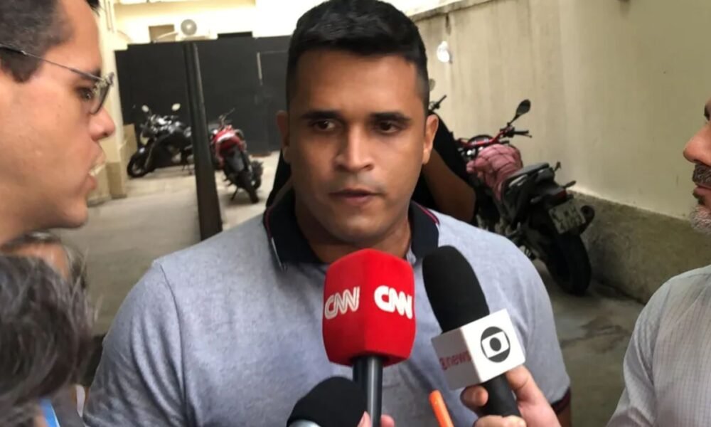 William Correia fala a jornalistas diante de microfones