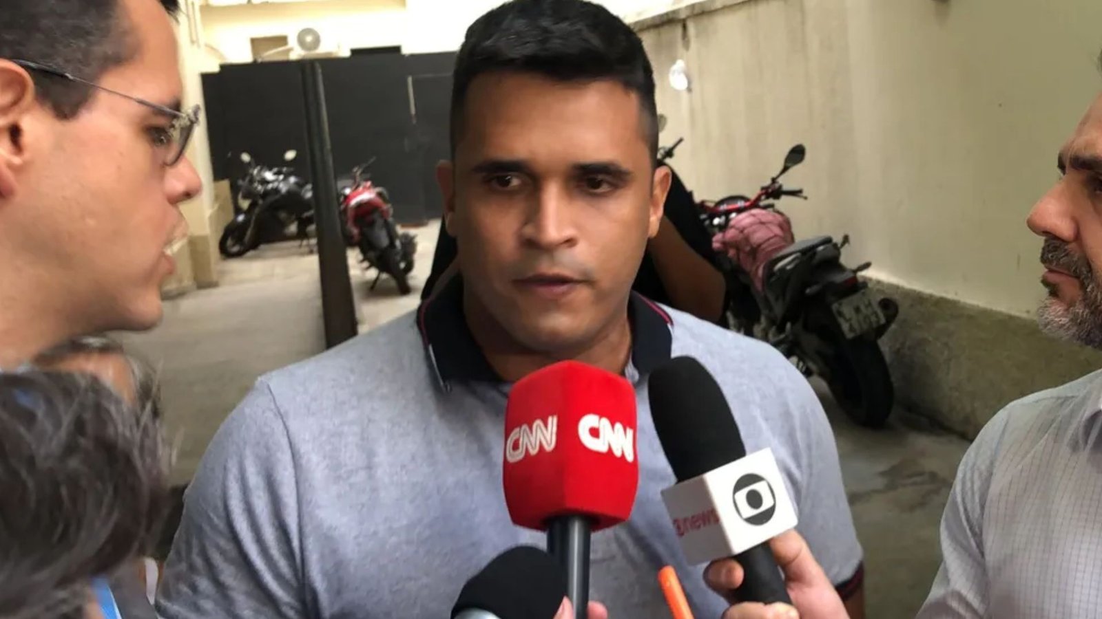 William Correia fala a jornalistas diante de microfones