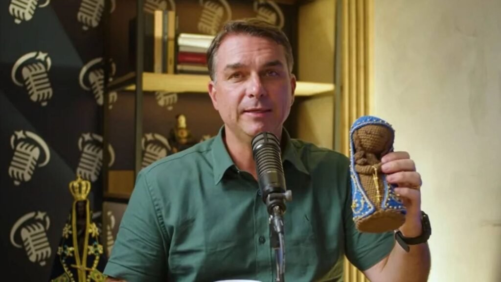 Flávio Bolsonaro segura uma imagem de Nossa Senhora Aparecida.