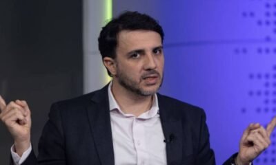 Renan Santos gesticula com as duas mãos em estúdio.