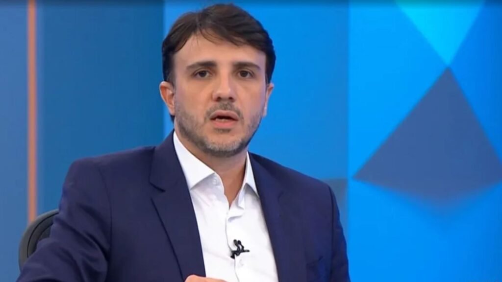 Renan Santos de paletó azul em estúdio