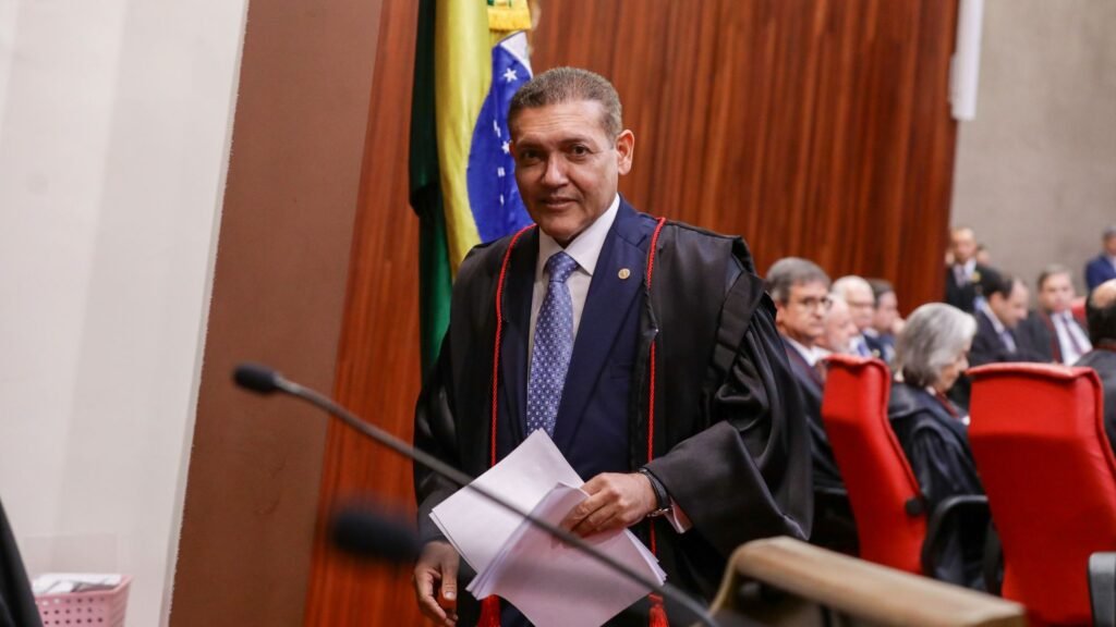 Nunes Marques de toga, segurando documentos.